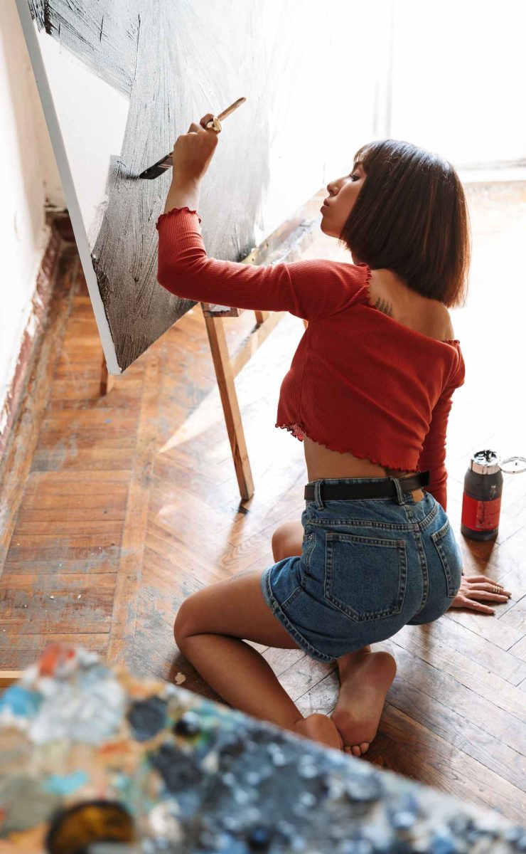 portrait-of-young-woman-using-painting-tools-while-92SJDEG