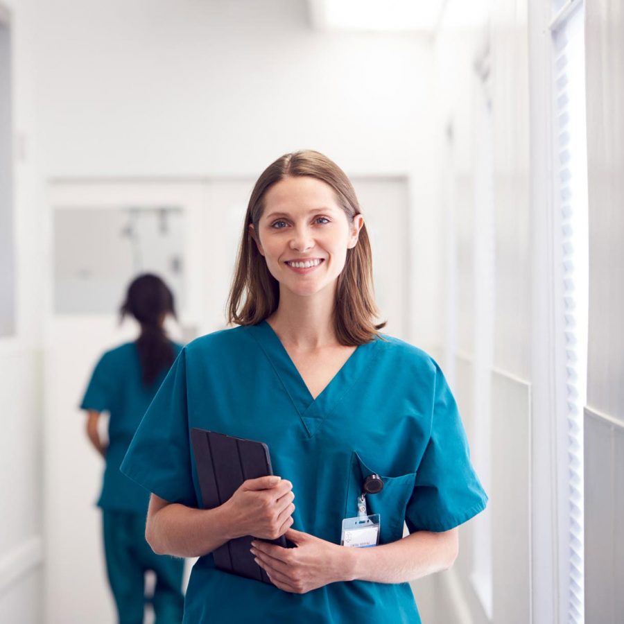 portrait-of-smiling-female-doctor-wearing-scrubs-HZ79GZQ-1