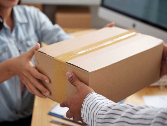 Delivery service manager giving parcel to courier