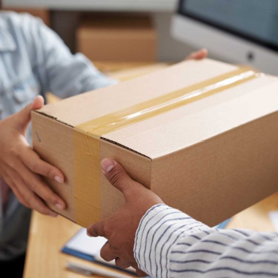 Delivery service manager giving parcel to courier