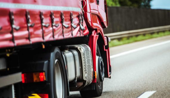Red Speeding Semi Truck on the European Highway. Transportation Industry.
