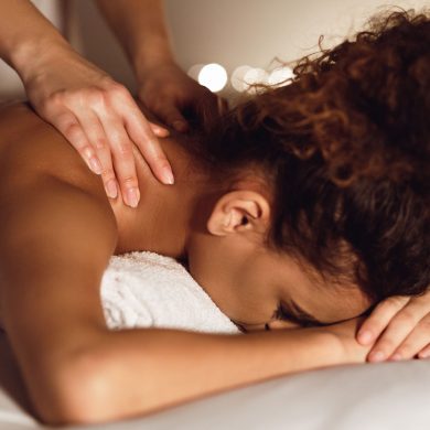 Woman enjoying therapeutic neck massage in spa center, closeup