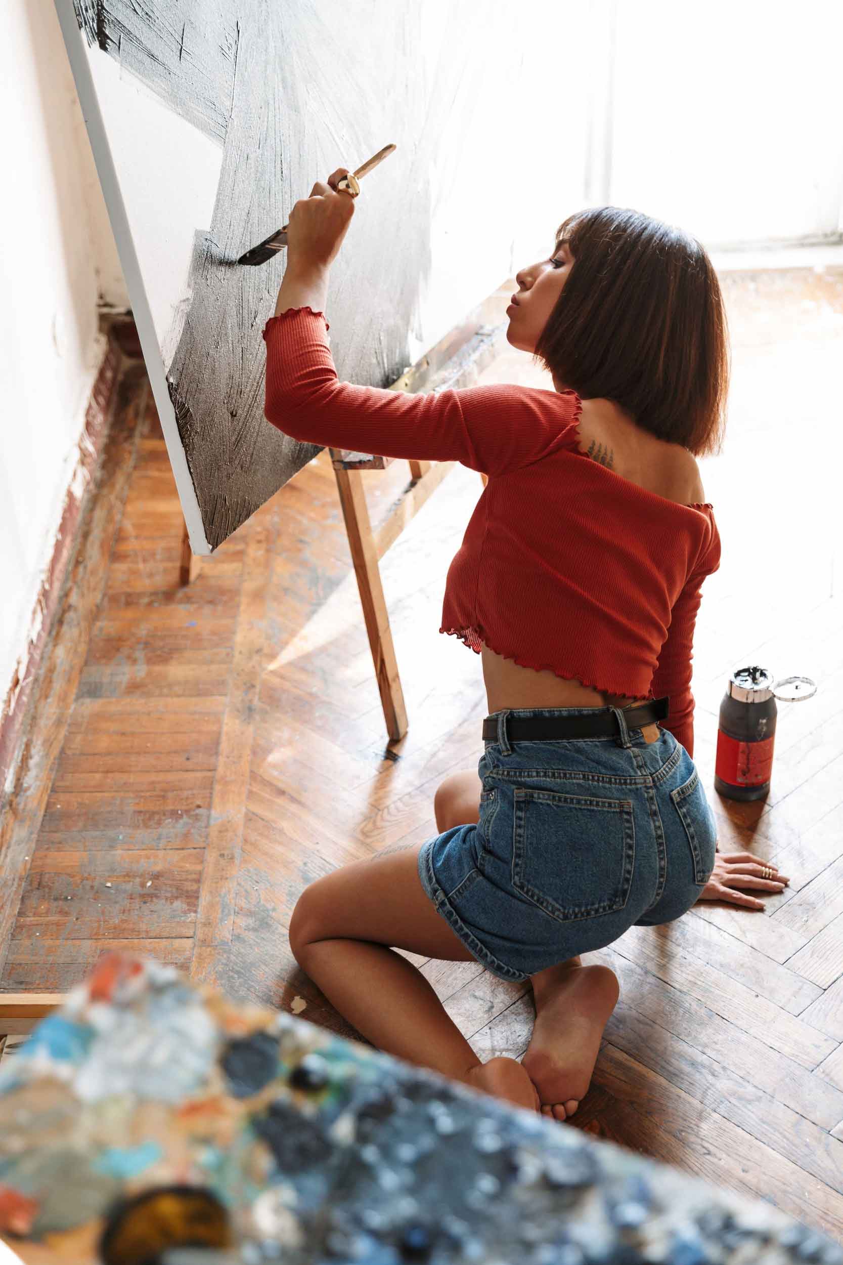 portrait-of-young-woman-using-painting-tools-while-92SJDEG