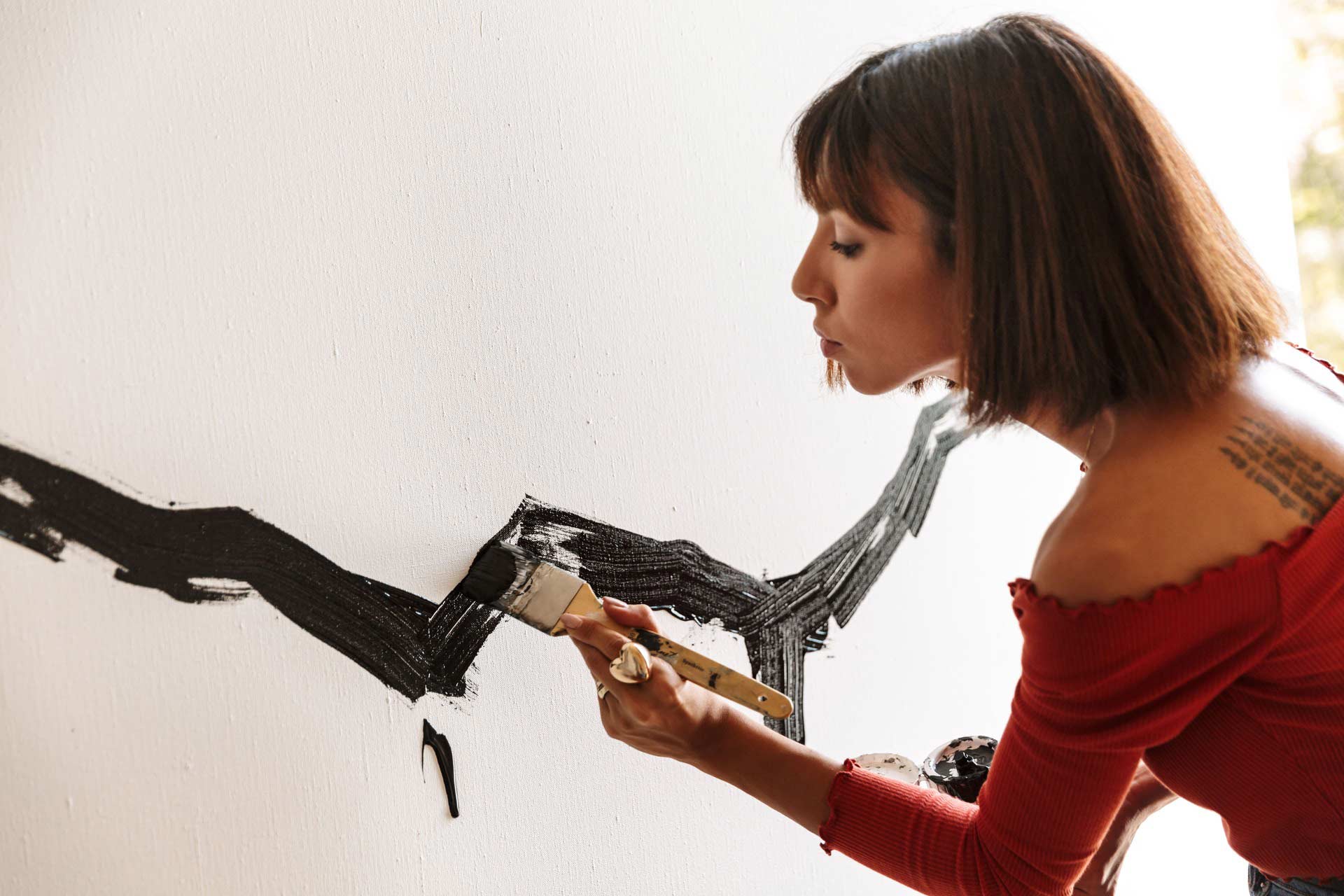 portrait-of-young-woman-using-painting-tools-while-XNWPWKQ