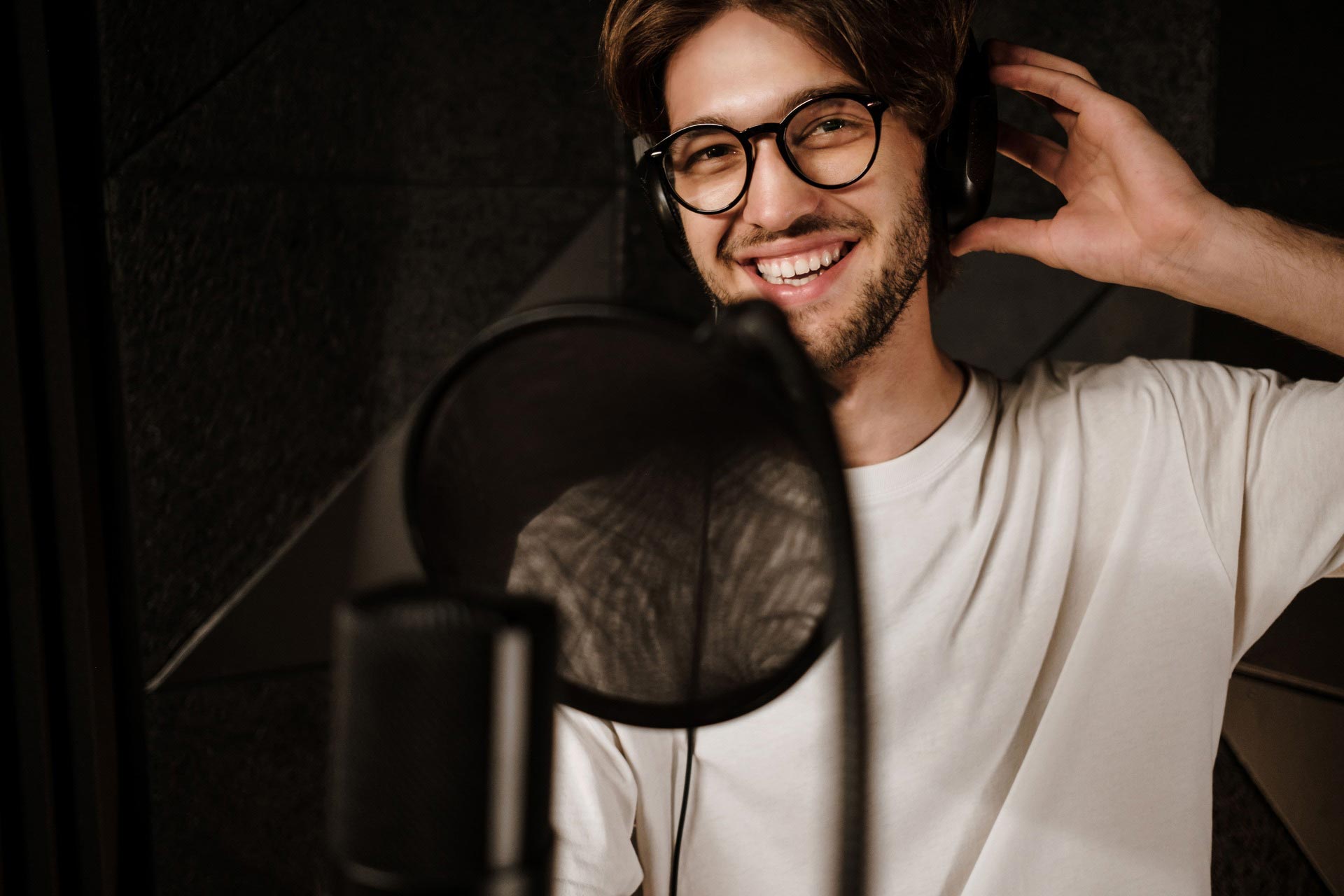 young-cheerful-male-singer-in-headphones-happily-l-6QF9EWK