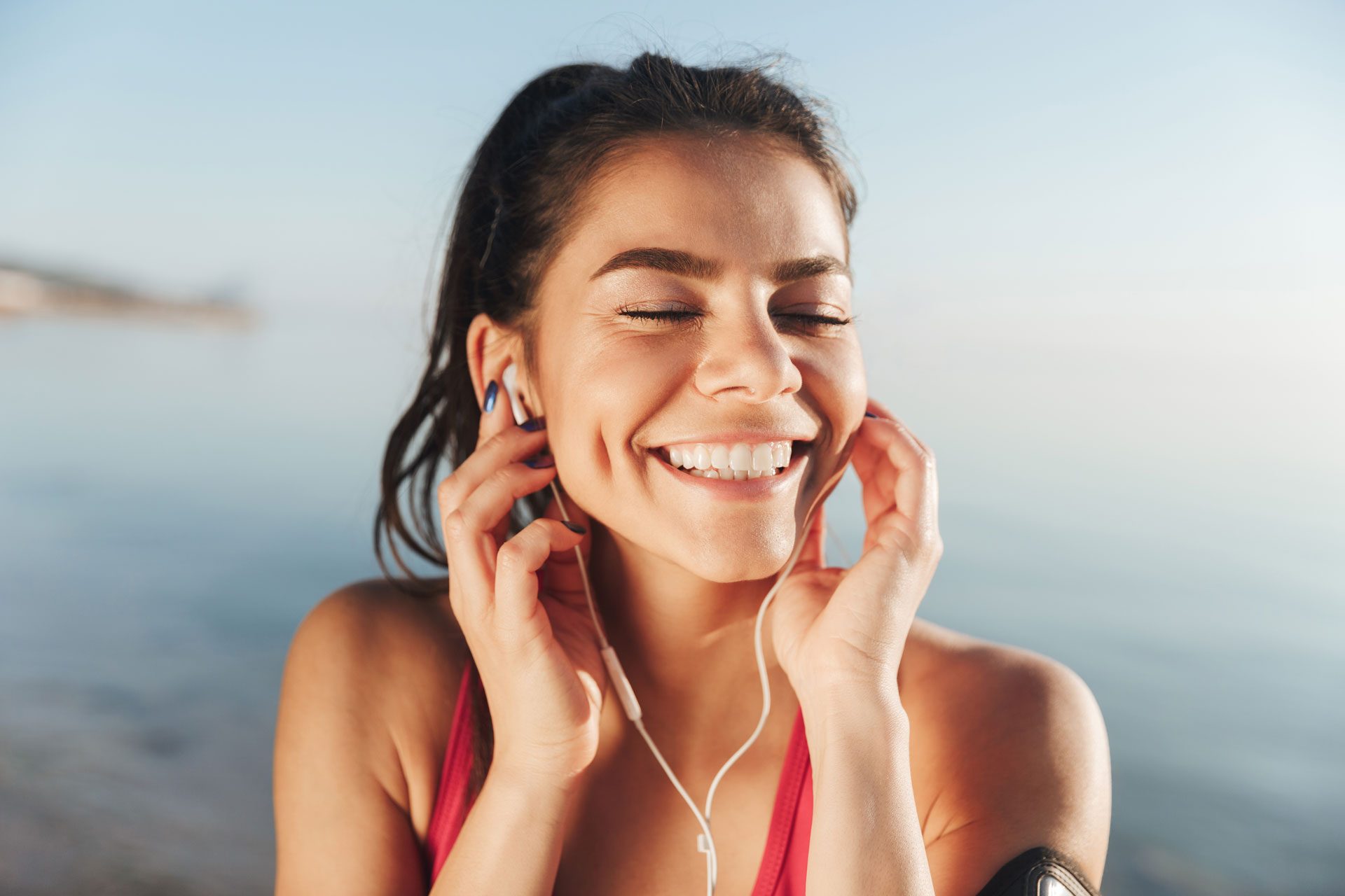 cheerful-sports-woman-listening-music-in-earphones-FJH6PY8.jpg